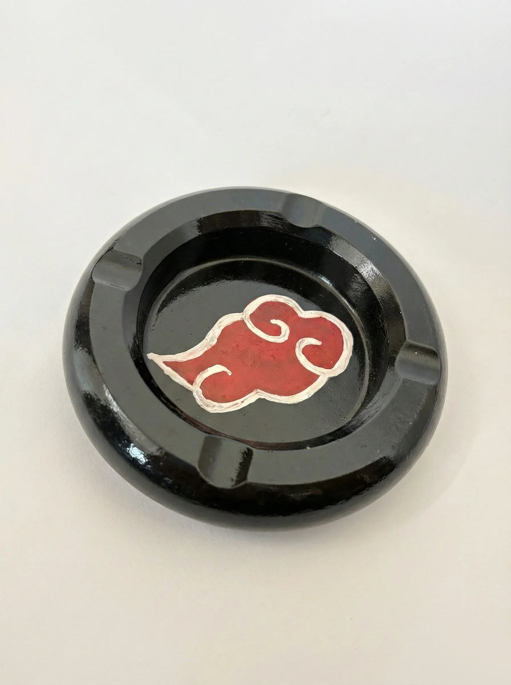 Black ashtray with a red akatsuki cloud symbol on a white background