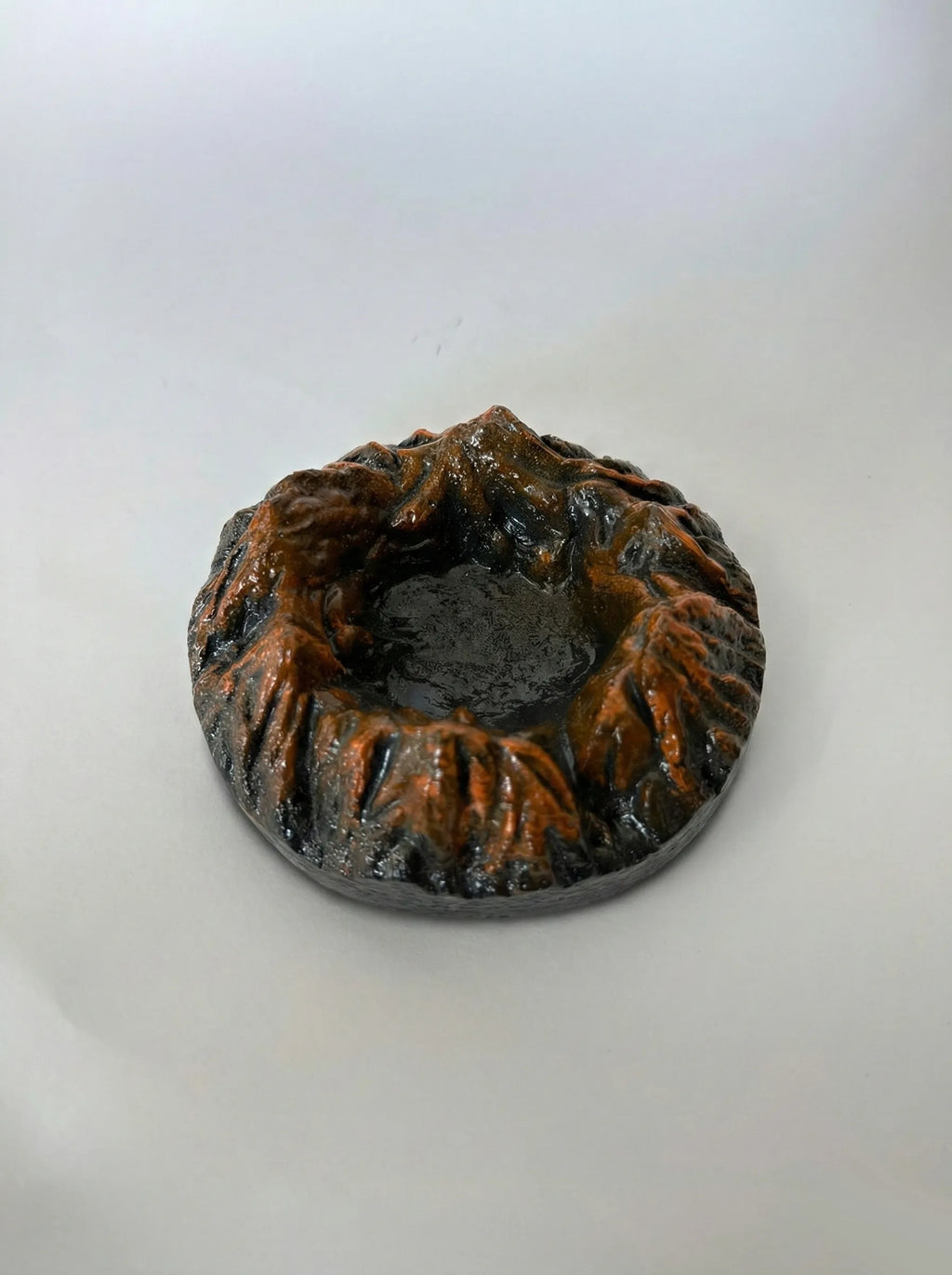 Black Magma ashtray with textured surface on a white background