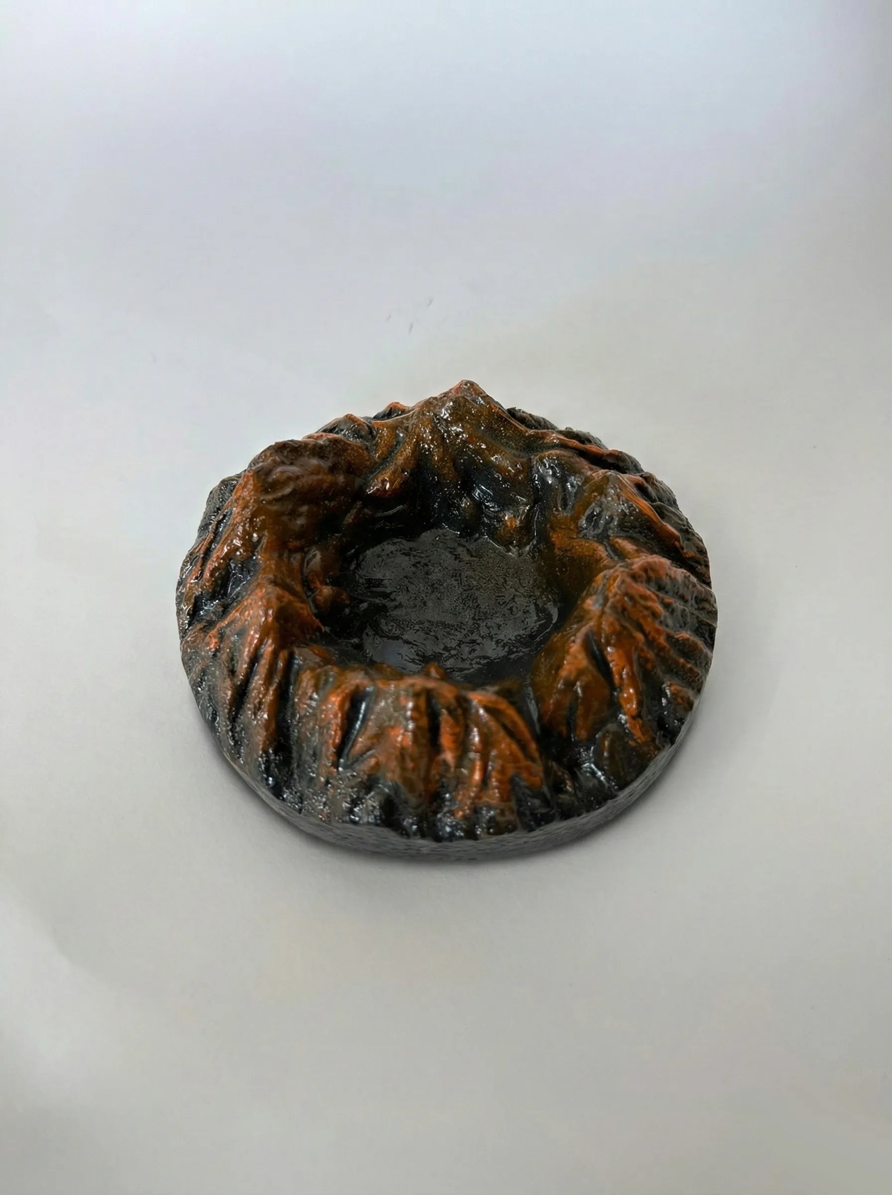 Black Magma ashtray with textured surface on a white background