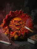 Designer ashtray with skull design and smoking accessories on a dark background