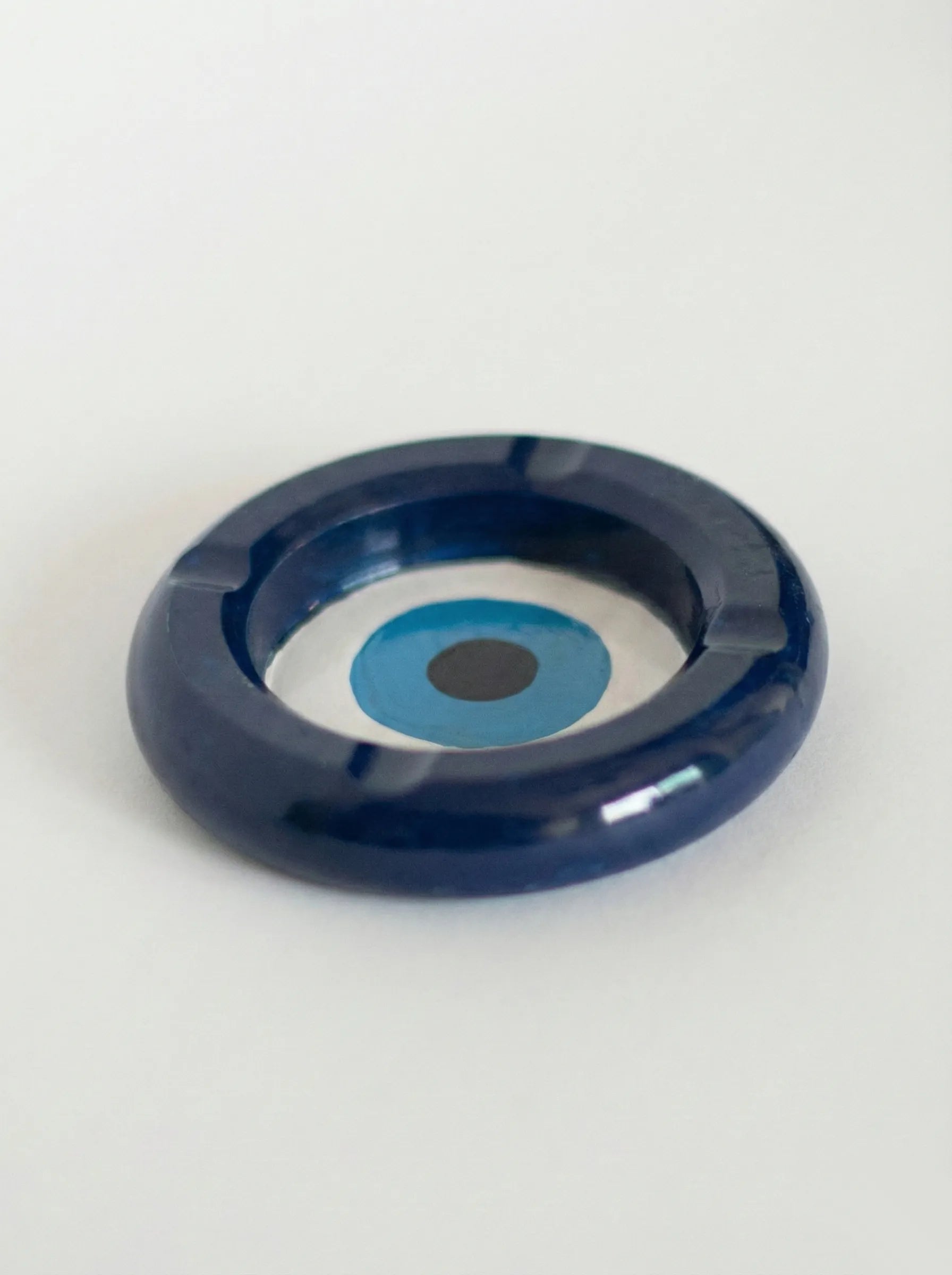 Blue concrete Evil Eye Ashtray with a white circle and black dot on a white background