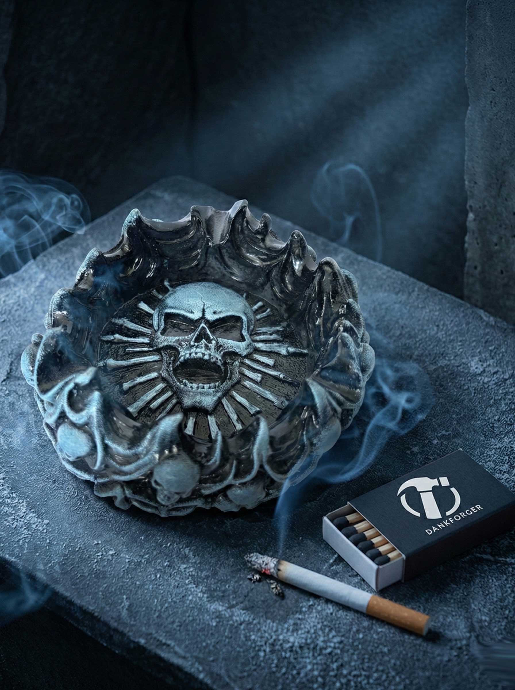 Designer skull ashtray with a lit cigarette and matches on a dark surface