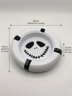 Circular ashtray with a mime face design and measurements on a white background