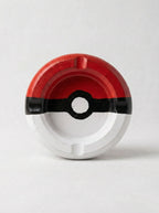 Circular pokeball ashtray with red, black, and white design on a light gray background