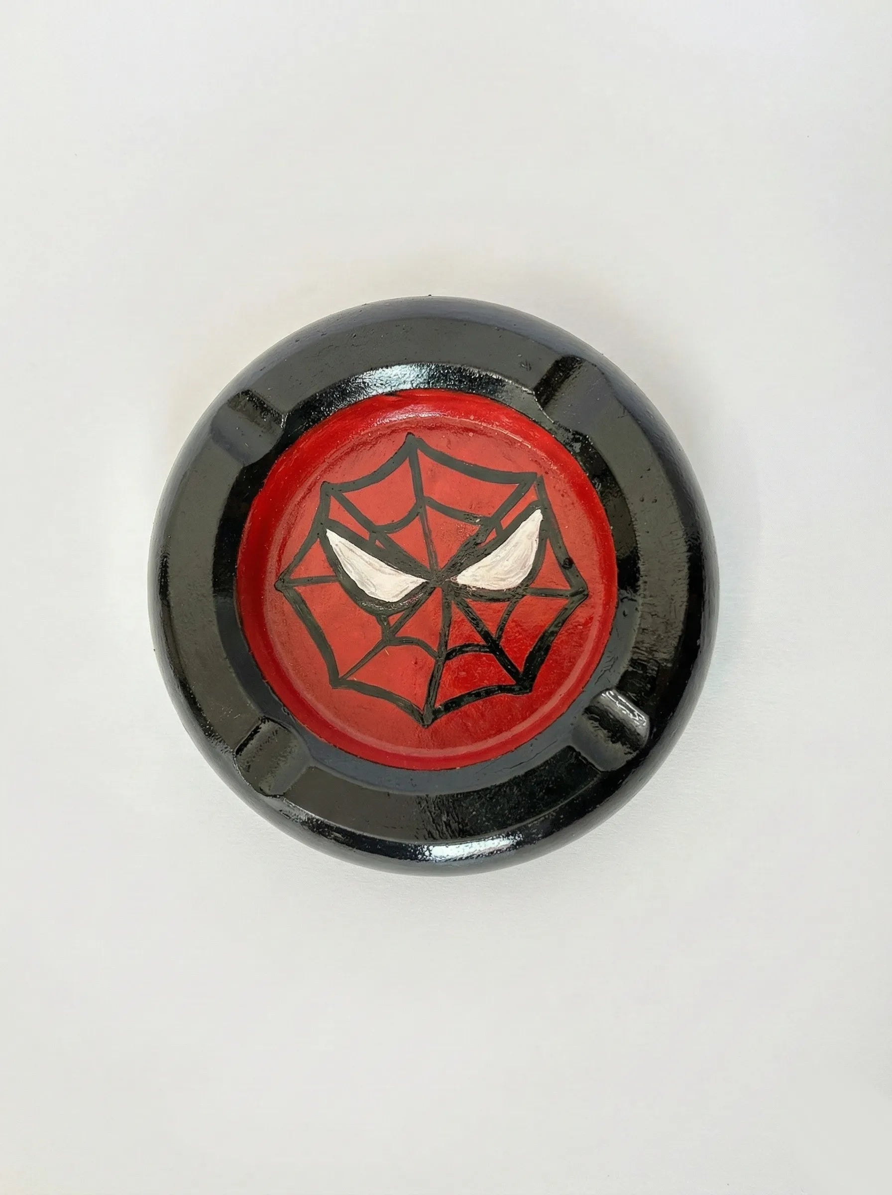 Round Spider-Man Ashtray with spider web design on a red background, on a white background