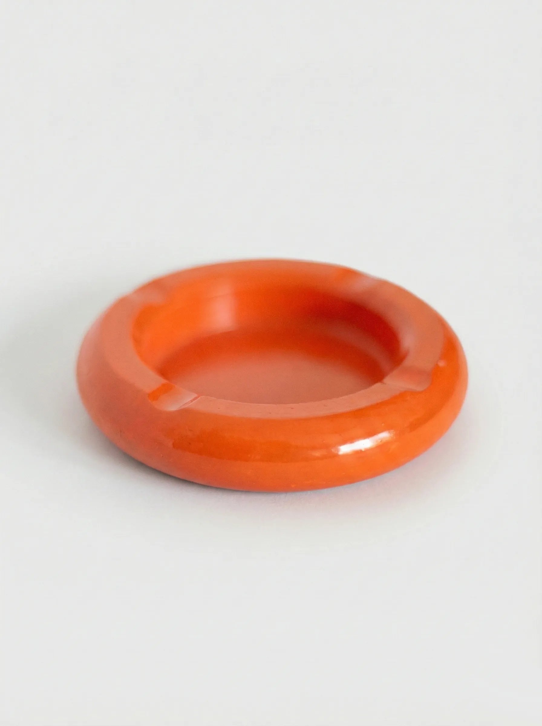 Orange concrete ashtray on a white background